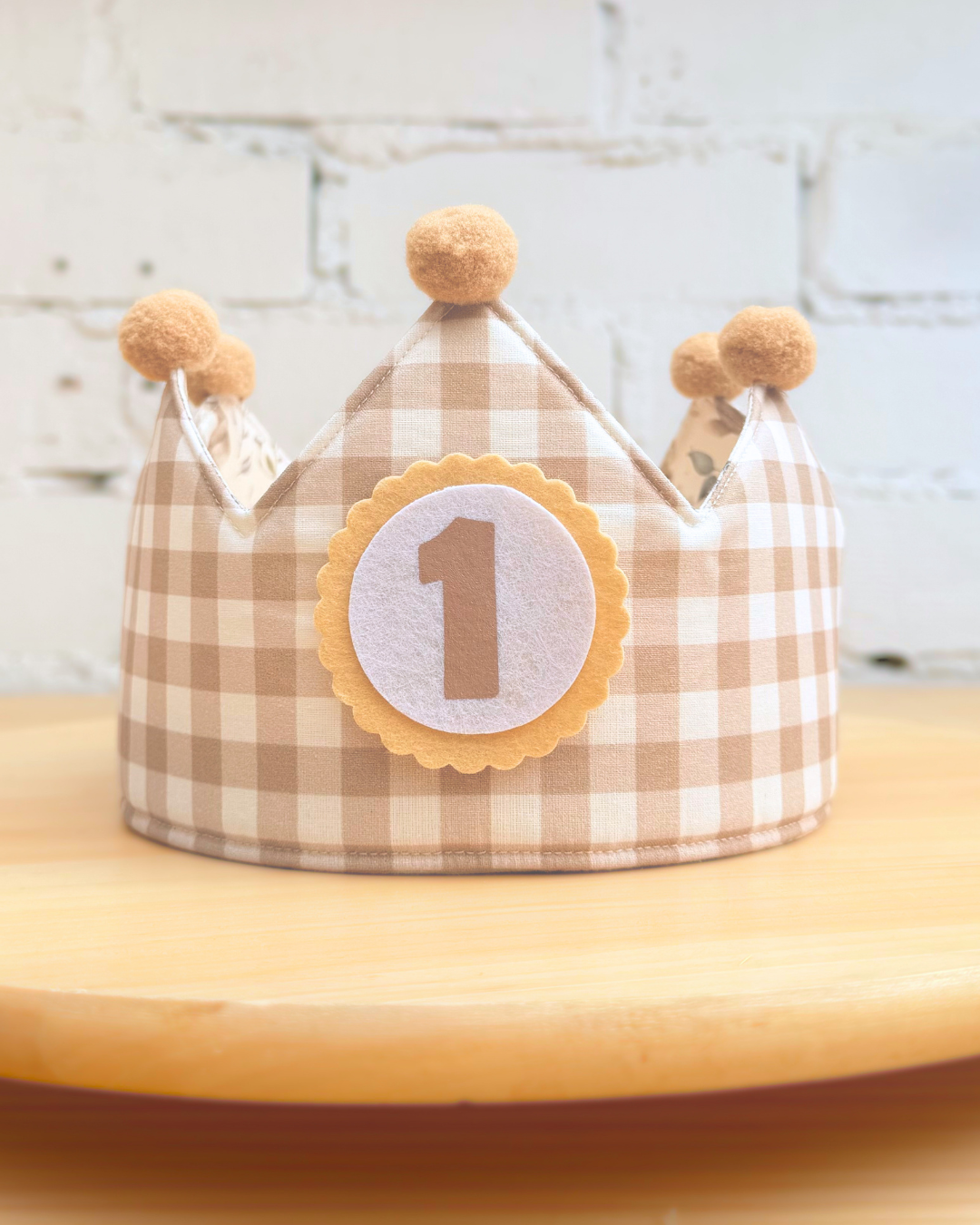 Cara reversible en vichy beige de la corona de cumpleaños, con pompones mostaza y el número 1