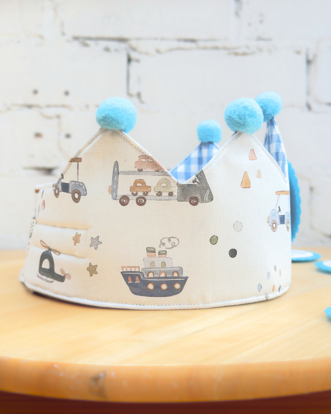 Corona de cumpleaños de coches vista desde atrás, con los pompones azules