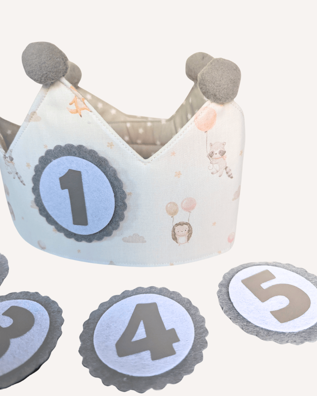 Detalle del estampado de globos en azul, con pompones grises y el interior de estrellitas