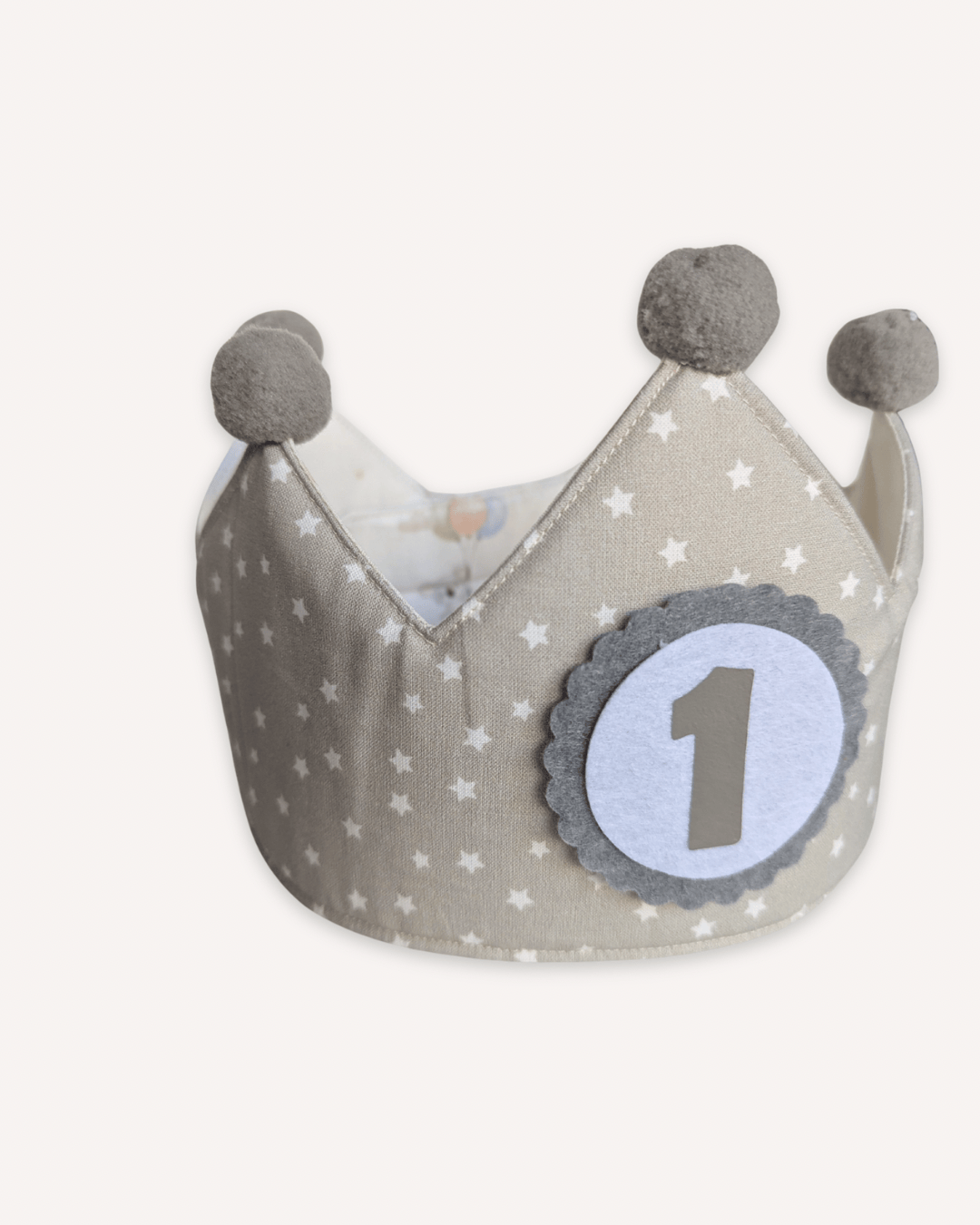 Detalle de la cara de estrellitas blancas sobre gris, donde se ve el interior con el estampado de globos