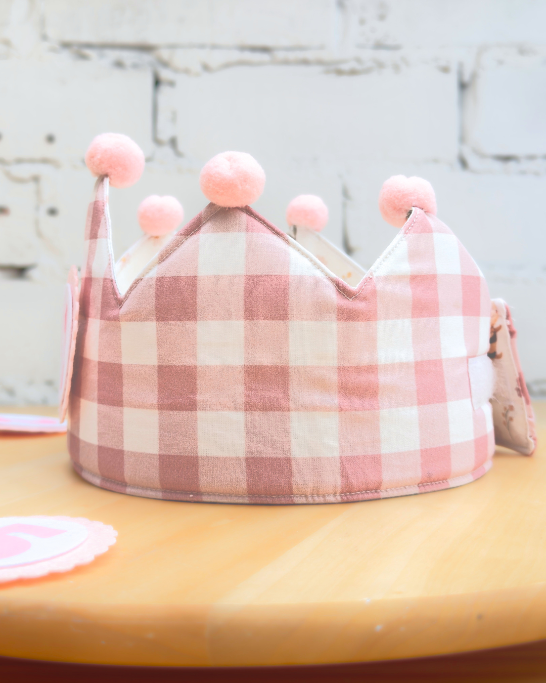 Cara de vichy rosa de la corona reversible, vista lateral con los pompones rosas