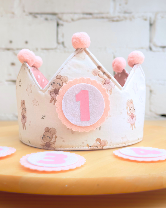 Corona de cumpleaños con estampado de ratoncitas y estrellitas, con pompones rosas y el número 1